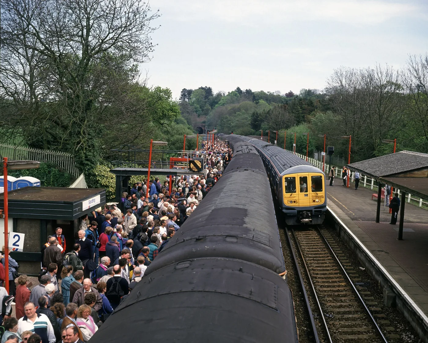 Probably more people than en:Sandling railway station platform has ever seen; on the left passengers disembark from the 'Tunnel Explorer' excursion, and on the right 319008 arrives with one of the trips back from the Channel Tunnel.  This was on 5 May 1994 as 